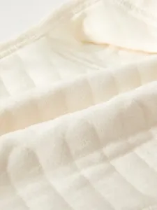 Close-up of quilted cotton fabric detail on newborn thermal baby undergarment