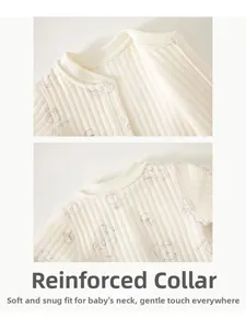 Détail de l'encolure en maille côtelée d'une grenouillère bébé en coton crème avec motif d'ours
