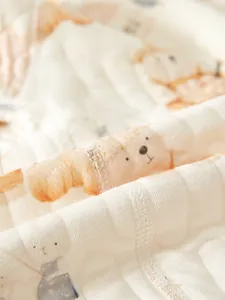 Détail du tissu en coton matelassé avec motifs ours et lapin pour barboteuse bébé