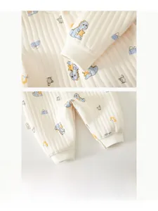 Detailed view of elastic ribbed cuffs and cartoon dinosaur print on baby quilted romper