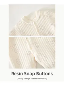 Détail de la barboteuse pour bébé avec boutons-pression en résine et tissu côtelé