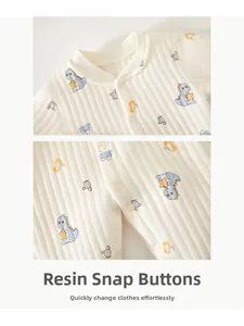 Macro detail of infant onesie with rib-knit fabric, dinosaur print and resin snap buttons