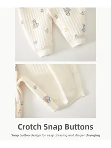 Detail of baby romper featuring snap buttons at crotch and ribbed cotton fabric with dinosaur print