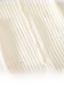 Vue macro d'un barboteuse bébé en maille côtelée avec motifs d'ours et de miel