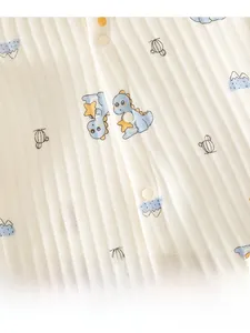 Detail of infant bodysuit showing soft rib-knit fabric with cute blue dinosaur prints