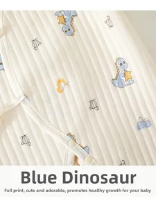 Detail of quilted baby bodysuit featuring blue dinosaur print and snap buttons