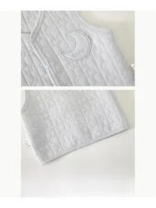 Detail of baby quilted vest with moon star pattern and snap buttons for newborns