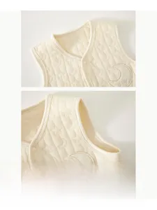 Detail of cream quilted baby vest with star patterns and moon embroidery patch