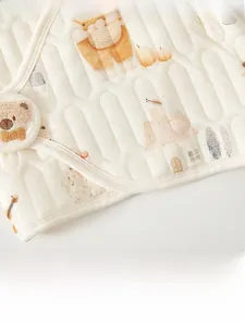 Close-up of quilted newborn thermal top featuring cute musical bear patterns