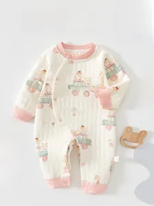 Détail d'une grenouillère matelassée pour bébé avec imprimé train d'animaux et finitions roses