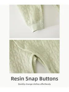 Detailed close-up of resin snap buttons on quilted star and moon pattern baby romper