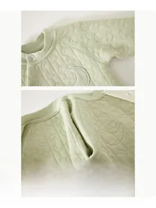 Detailed view of seamless stitching and quilted moon pattern on light green baby romper