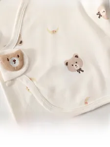 Dettaglio di maglietta in cotone per neonati con stampe di orsi e applique 3D