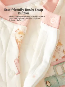 Détail d'une barboteuse matelassée pour bébé avec pressions en résine POM et motifs girafe