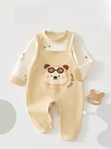 Detailed close-up of cartoon bear embroidery and button crotch on cotton baby overall set