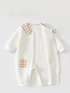 Detail of baby romper with full snap buttons and checkered collar on ribbed cotton fabric