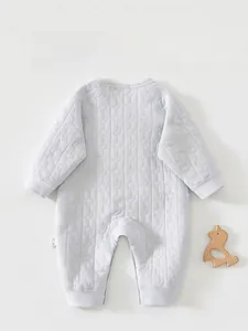 Détail d'une grenouillère matelassée pour bébé avec texture étoiles et lunes