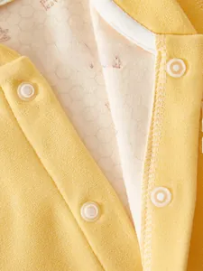 Macro detail of yellow cashmere cotton baby romper with eco-friendly resin snap buttons