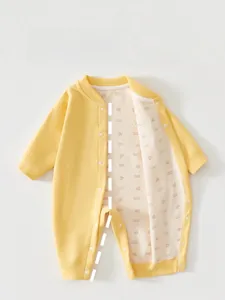 Detailed view of yellow newborn romper with maple leaf printed lining and snap buttons
