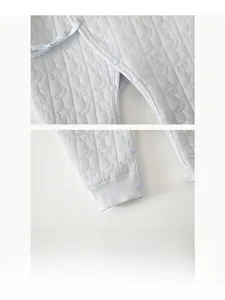 Détails des boutons-pression en résine sur barboteuse matelassée avec lunes et étoiles