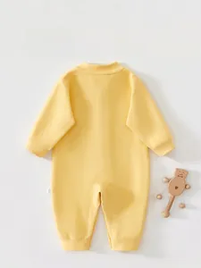 Detail view of the back seams and yellow cashmere silk fabric of the newborn romper
