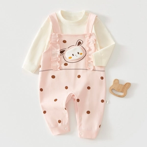 Detailed flat lay of baby cotton set with pink polka dot overalls and cute bunny patch