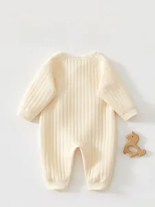 Vue arrière détaillée d'un body bébé crème avec texture côtelée et tissu doux et souple