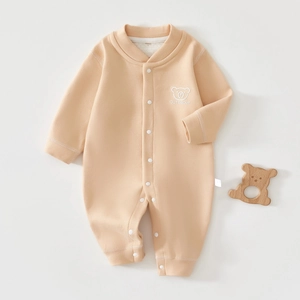 Close-up of beige newborn bodysuit featuring CuteBear embroidery and snap buttons