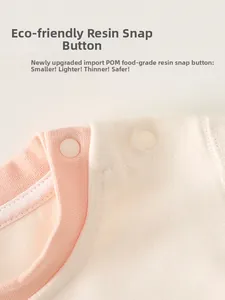Macro detail of baby romper neckline featuring eco-friendly resin snap buttons