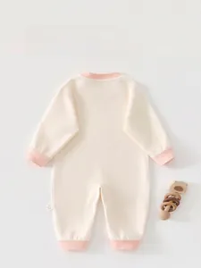 Detail view of baby romper back with cream knit fabric and pink ribbed cuffs