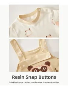 Detail of infant cotton sweater and romper with resin snaps and cute cartoon bear print