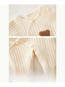 Détails de la combinaison matelassée pour bébé avec boutons et broderie ours