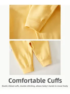 Detail view of ribbed cuffs and double stitching on yellow newborn cashmere romper