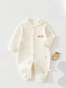 Close-up of baby romper with soft ribbed cotton texture, cherry print and pink bow detail