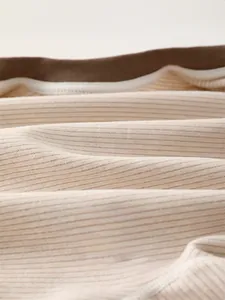 Close-up of baby romper showing soft rib-knit cotton fabric and breathable texture