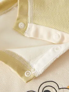Close-up of baby winter jumpsuit featuring white resin snap buttons and quilted texture