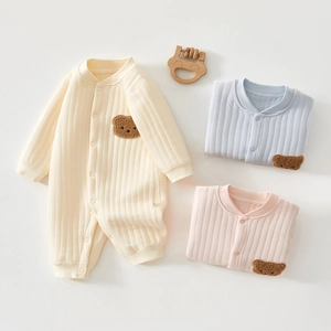 Détail de grenouillères à rayures pour bébé avec écusson ours en trois coloris doux