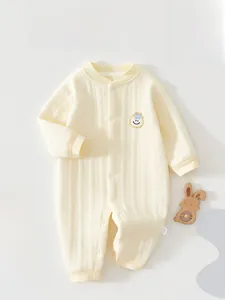 Detail of cream waffle knit baby romper featuring soft cotton fabric and snap buttons