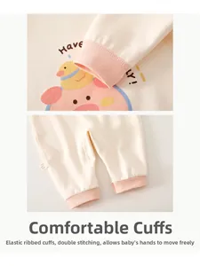 Detailed view of elastic ribbed pink cuffs and double-stitched hem on white baby romper