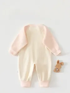 Detailed macro view of the baby romper's knitted jacquard texture and ribbed cuffs