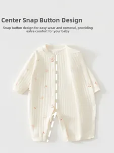 Detail of baby cotton romper featuring cherry print and snap buttons for easy dressing