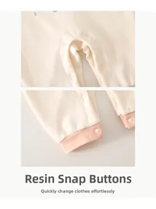 Detailed close-up of resin snap buttons on baby romper with soft knit fabric