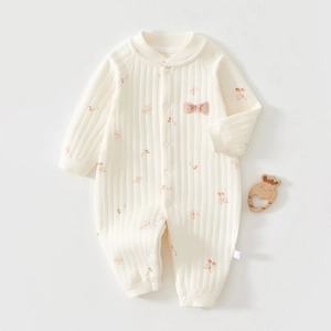 Close-up of quilted cotton baby romper with cherry patterns and snap buttons