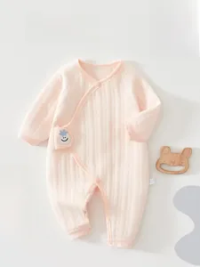 Detail of light pink quilted cotton baby romper with soft texture and cartoon patch