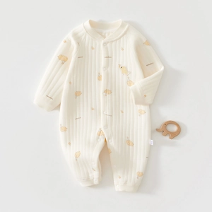 Detailed view of cream baby romper with elephant prints and ribbed cotton texture