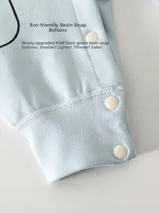 Detail of eco-friendly food-grade POM resin snap buttons on soft blue infant clothing