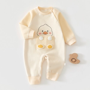 Detailed close-up of cream baby romper featuring herringbone texture and cartoon duck