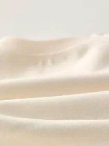 Macro close-up showing soft breathable cotton fabric texture of the baby clothing set