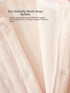 Detail of pink baby romper featuring eco-friendly resin snap buttons and soft knit fabric