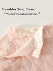 Gros plan sur un haut matelassé rose pour bébé avec boutons-pression à l'épaule pratiques
